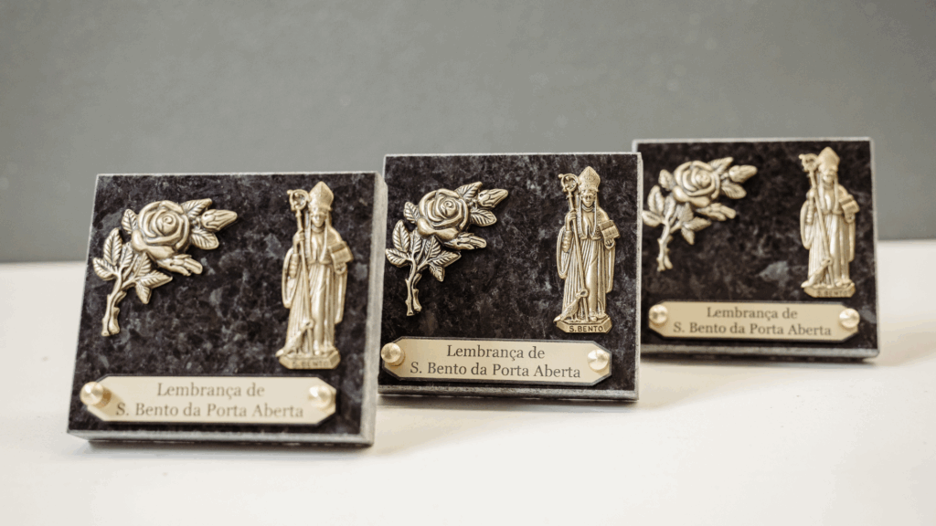 Pedras funerárias com bronzes e motivos religiosos, produzidas com precisão tecnológica e acabamento artesanal detalhado.
